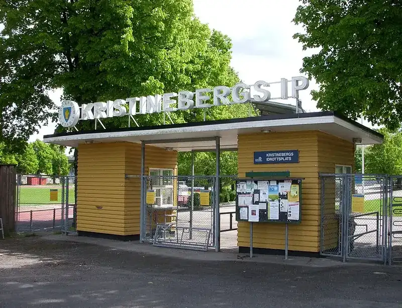 Gul entrébyggnad med skylten Kristinebergs IP och anslagstavlor vid grindarna